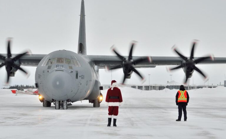 A Royal Canadian Air Force Hercules arrives on a snowy runway as Santa waits, during the Toys for the North delivery